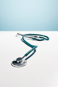 Medical stethoscope on a white surface against a blue background