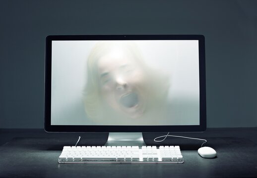 Screaming woman trapped inside computer screen