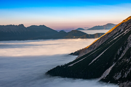 Fog covering the valley in the Austrian Alps at sunset