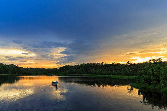 Ecuador, Amazon River region, dugout canoe on Lake Pilchicocha at sunset