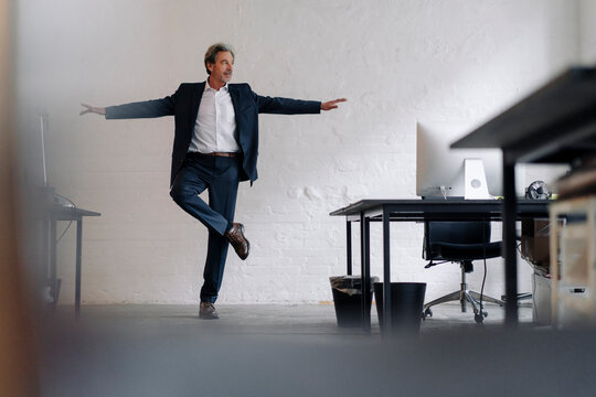 Senior businessman doing a yoga exercise in office