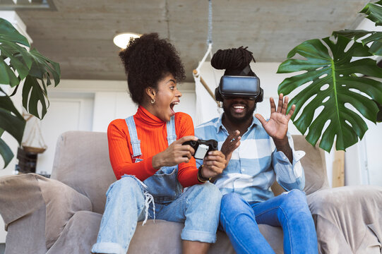 Cheerful couple playing video game at home