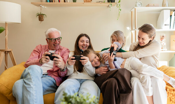 Happy family bonding and playing video game together at home