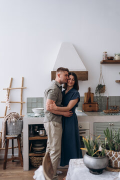 Loving partners embracing and smiling in rustic home kitchen