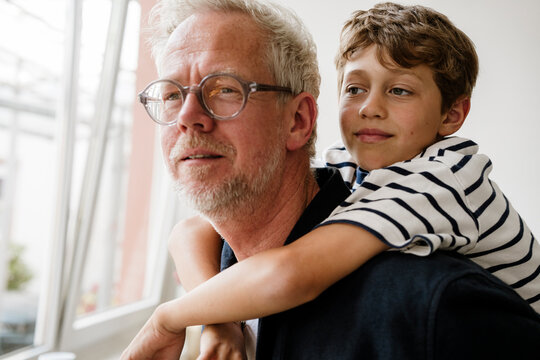 Father and son enjoy a piggyback ride at home