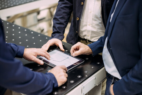 Businessmen discussing strategy with a tablet in an office setting