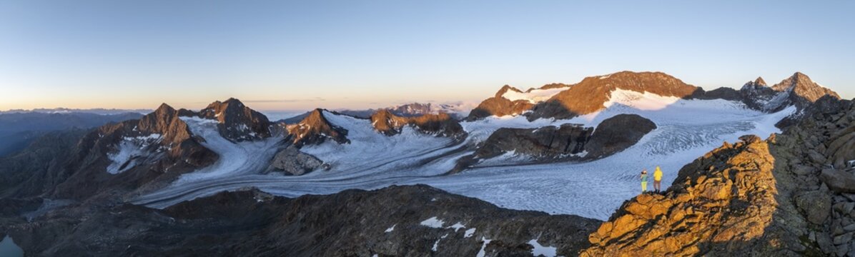 Panorama, atmospheric sunrise in a picturesque mountain landscape, alpenglow, aerial view, mountaineer on the summit of Becher and &Uuml;beltalferner glacier, Stubai Alps, South Tyrol, Italy