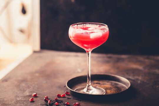Glass of pomegranate fizz with pomegranate juice, ice cubes and tonic water