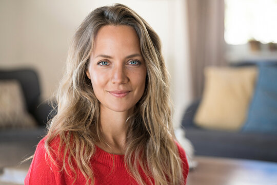 Portrait of smiling blond woman at home