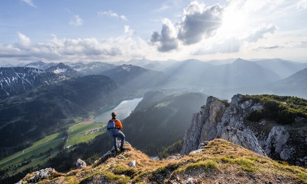 Hiker at the summit of Schartschrofen at sunset, view of Haldensee and Allg&auml;u Alps, Tannheimer Berge, Allg&auml;u, Bavaria, Germany