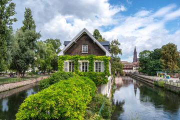 Fototapeta premium House covered with green ivy by the canal Strasbourg, France