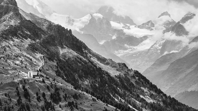 The historic Hotel Weisshorn below the Weisshorn mountain, behind the four-thousand-metre peaks and glaciers in clouds, drone shot, black and white image, Val d'Anniviers, Valais Alps, Canton Valais, Switzerland