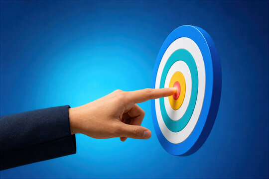 Business person hand touching colorful target bullseye with finger concept of goal setting focus precision success achievement strategy and hitting objectives on blue gradient background