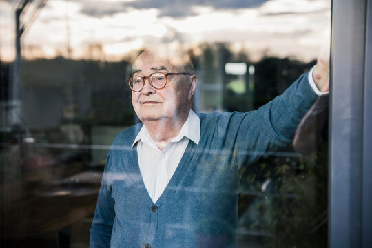 Portrait of serious man at the window looking out