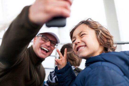 Laughing father taking a selfie with his son