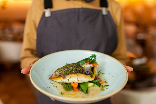 Waitress serving healthy fish and veggies