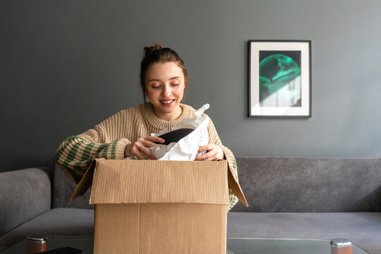 Smiling woman unpacking box at home
