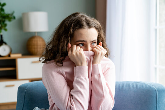 Afraid woman covering mouth at home