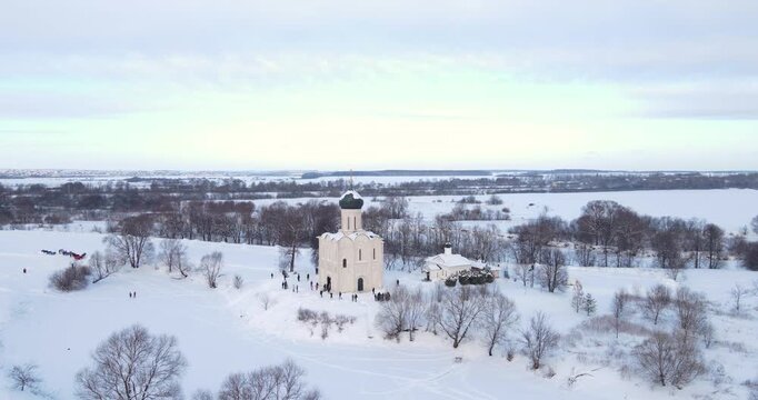 Cinematic aerial drone orbit shot of the historic Church of the Intercession on the Nerl in a snowy winter landscape
