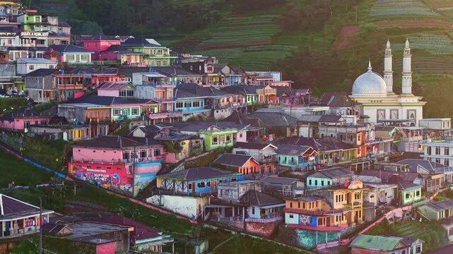 Aerial view of Beautiful hillside settlement with vibrant houses sunbathed with sunlight, drone view of rural mountain village and natural scenery. Nepal Van Java village, Indonesia.