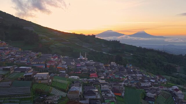 Sunrise view of rural village on hillside, warm light across terraces and natural mountain scenery. Nepal Van Java, Indonesia.