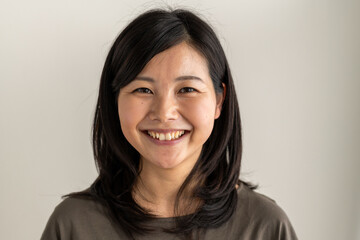 Obraz premium Smiling person with dark hair against a neutral background.
