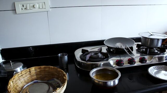 Realistic home kitchen scene after cooking with used cookware, gas stove, utensils, and food preparation items. Ideal for domestic lifestyle, household routine, and cleanup concepts.
