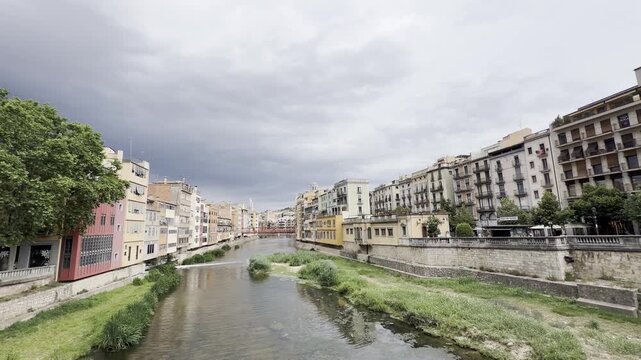 Colorful Onyar River houses and bridges in Girona, Spain on a cloudy day