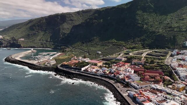 Aerial drone pan over Garachico coastal town and volcanic pools, Tenerife, Spain