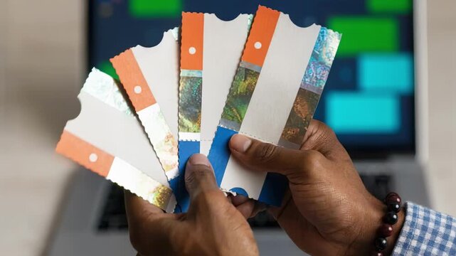 Medium shot of hands holding verified sports tickets in front of a blurred digital escrow contract on a laptop screen emphasizing secure resale process.