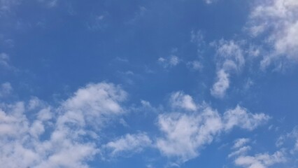 Obraz premium Scattered White Clouds across a Bright Blue Sky