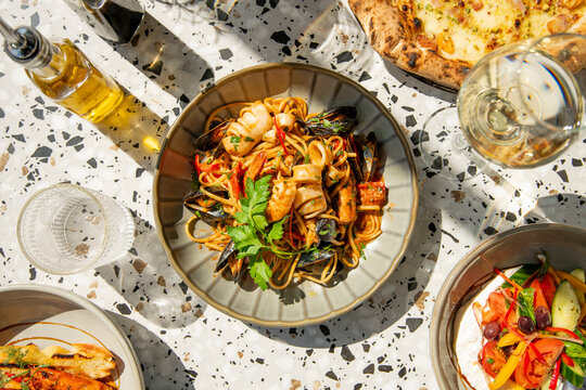 Enjoying a Vibrant Seafood Pasta Feast Under the Warm Afternoon Sun