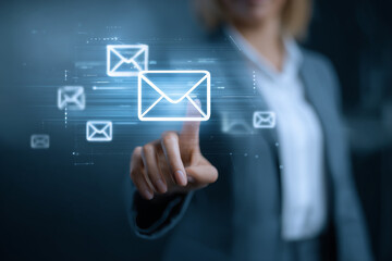 Obraz premium Digital Communication Interface: A businesswoman's finger points to a glowing digital interface displaying email icons, representing the modern era of online correspondence and global connectivity.