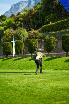 boy with a paraglider on the green landing field