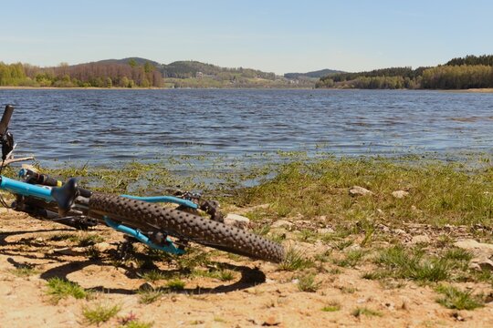 A serene lakeside scene with clear blue water reflecting the sky - Biking at Lake Lipno in Czech Republic