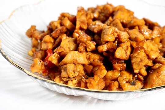 Close up sweet and savory tempe orek indonesian dish on transparent plate isolated on horizontal white background.