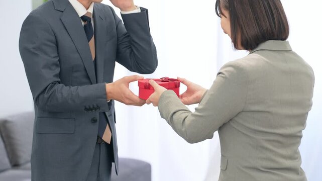 オフィスでプレゼントを渡すビジネスパーソン