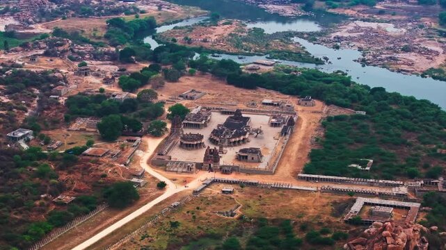 Temple ruins with Vitthal Mandirv, The Stone Chariot, Kalyana Mantapa and Tungabhadra river at hampi, nimbapura, vijayanagara, karnataka, india. day time, semi orbit shot, drone shot, 4k.