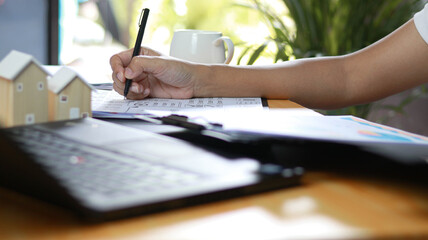 Business professional reviewing financial documents and real estate investment reports at office...