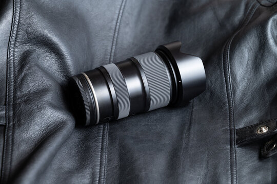 A modern camera zoom lens in a dark background