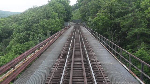 view from back of new jersey train from moodna viaduct of valley between mountains upstate new york (transit rail track railroad travel commute commuter line) port jervis new york