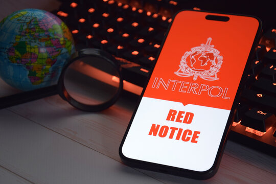 The smartphone with Interpol logo displayed on screen. International Criminal Police Organization or Interpol.