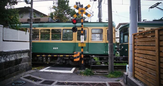 Slow motion steady cam shot on Japanese tram passing through village