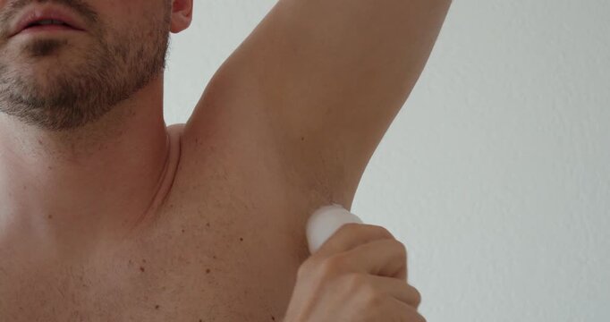 man using a roll-on deodorant directly on the underarm area. Suitable for personal hygiene, body care, sweat protection, grooming, freshness, men&rsquo;s wellness, and daily self-care routines.