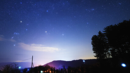 Obraz premium Constellations, zodiacal light and Milky Way stars on a dark countryside skies.