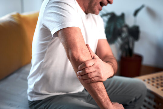 Man with elbow pain at home.