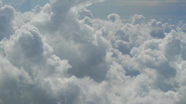 Airplane flying over a scenic sea of clouds, beautiful aerial view of the sky from the window, peaceful weather landscape with sunlight illuminating the atmosphere