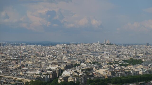 Expansive aerial panorama of paris, france featuring the iconic sacr&eacute;-c&oelig;ur basilica in montmartre under a beautiful blue sky with moving clouds on a sunny day