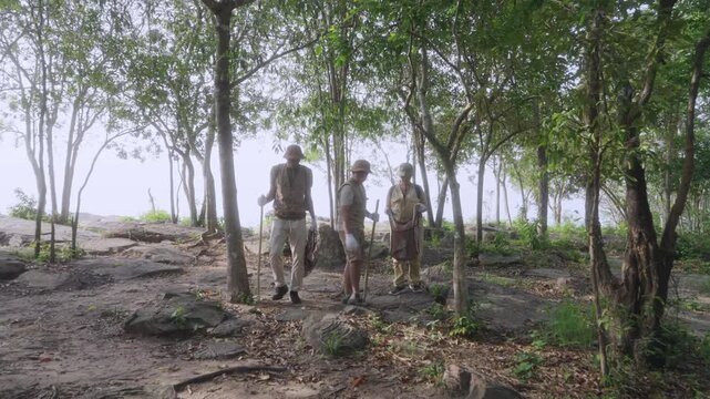 Asian family collecting litter in reusable bags while hiking on a forest trail. Concept of environmental stewardship, sustainable tourism, eco-friendly family activities, and Leave No Trace.