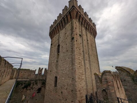 Imponente castello in pietra con torri merlate e mura storiche sotto un cielo grigio, per un&rsquo;atmosfera medievale forte e suggestiva